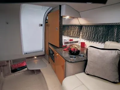 Slide: The Image of 2004 Formula 330 Sun Sport boat docked near waterfront homes, with outdoor seating area. - 4