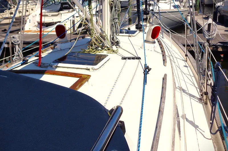 Slide: The Image of Sailboat deck of 1995 Pacific Seacraft 37, featuring ropes and hatches at a marina. - 8