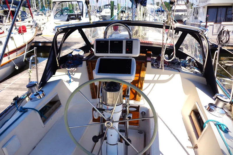 Slide: The Image of Cockpit of a 1995 Pacific Seacraft 37 sailboat, featuring steering wheel and navigation instruments. - 9