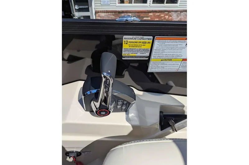 Slide: The Image of Control panel of 2026 Alera M23L boat with throttle and capacity warning labels. - 14