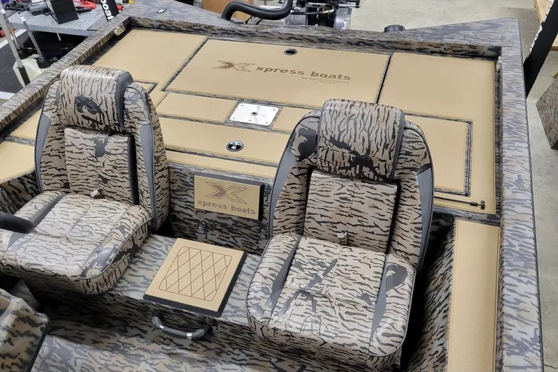Slide: The Image of 2026 Xpress H20C Crappie boat interior with camouflage seats and storage compartments. - 8