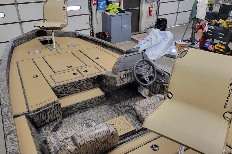 Slide: The Image of 2026 Xpress H20C Crappie boat interior with camo design in a garage setting. - 3