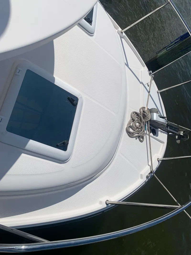 Slide: The Image of 2020 Ranger Tugs R-25 boat deck with rope and hatch, docked on water. - 11