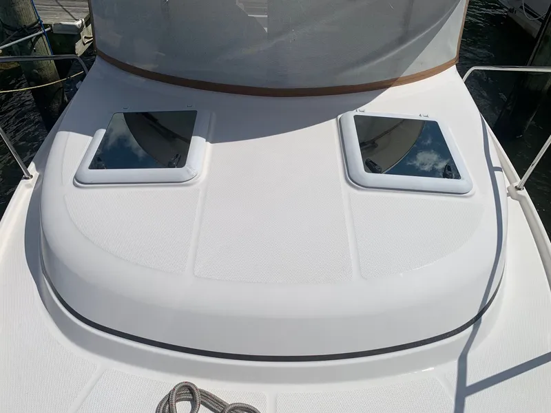 Slide: The Image of 2020 Ranger Tugs R-25 boat deck with two hatches, docked at marina. - 15