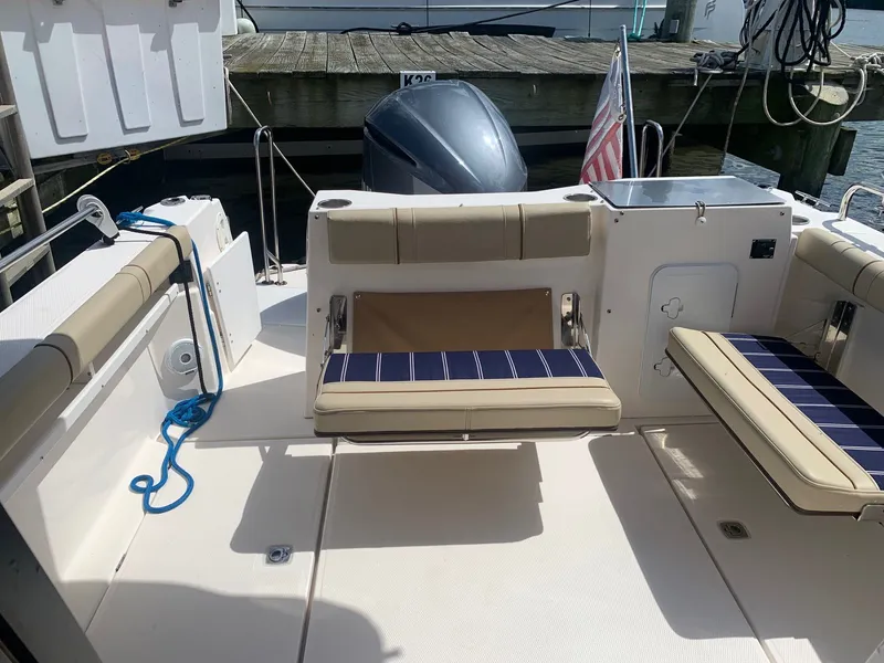 Slide: The Image of 2020 Ranger Tugs R-25 boat interior with seating and motor at dock. - 17