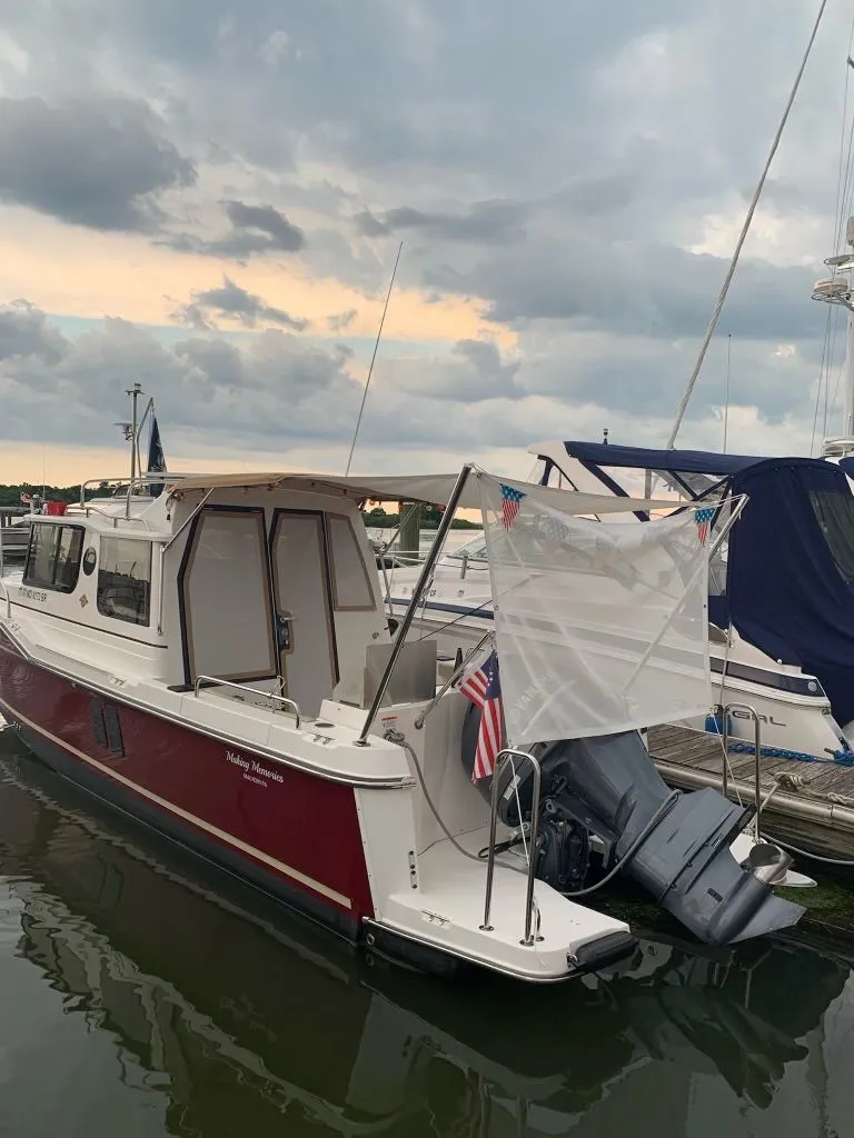 Slide: The Image of 2020 Ranger Tugs R-25 boat docked at marina under cloudy sky. - 2