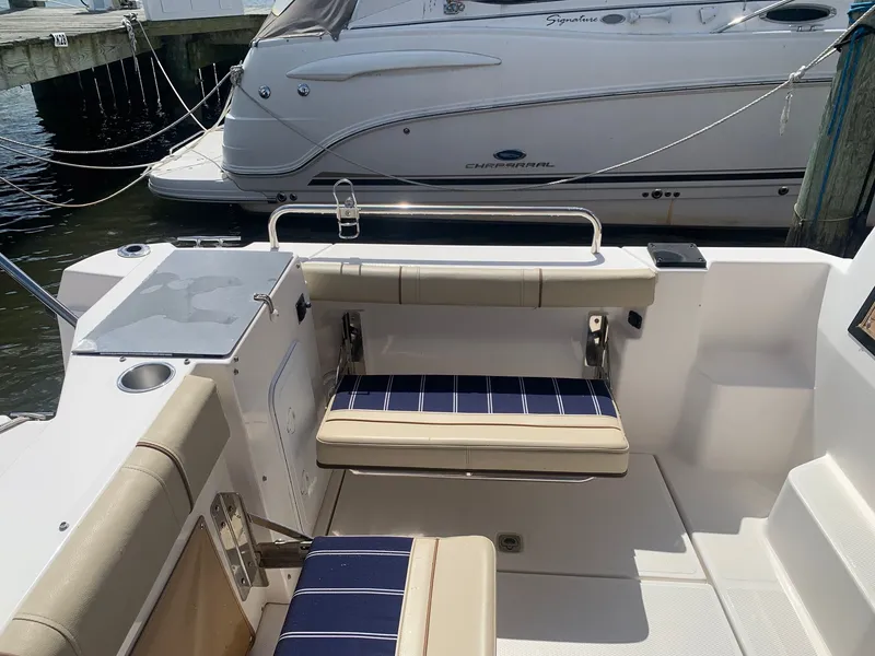 Slide: The Image of 2020 Ranger Tugs R-25 boat interior with seating and docked Chaparral in background. - 20