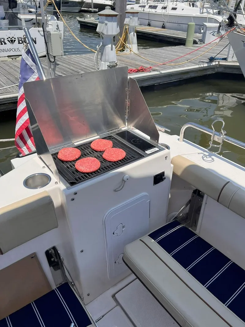 Slide: The Image of Grill with burgers on a 2020 Ranger Tugs R-25 boat at a marina. - 22