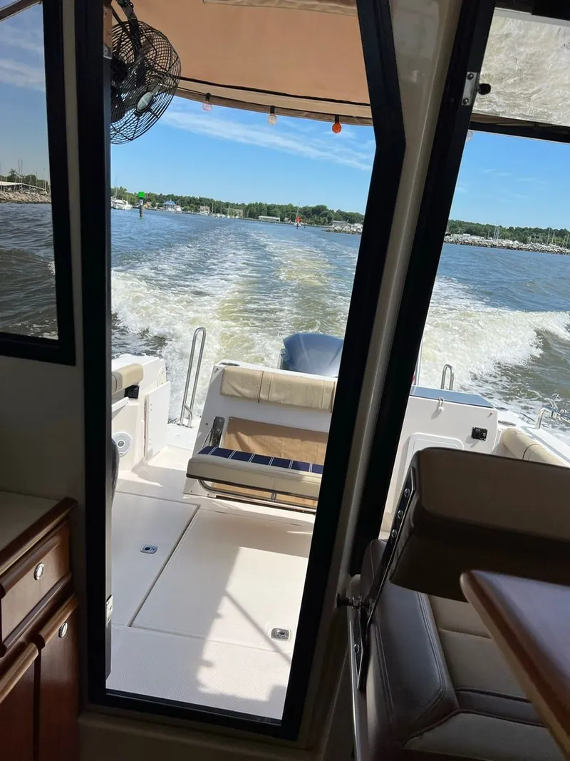 Slide: The Image of Interior view of 2020 Ranger Tugs R-25 boat, looking out to water and wake. - 24