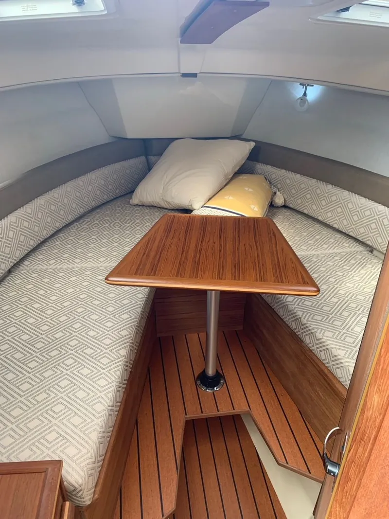 Slide: The Image of Cozy interior of 2020 Ranger Tugs R-25 with wood table and cushioned seating. - 29