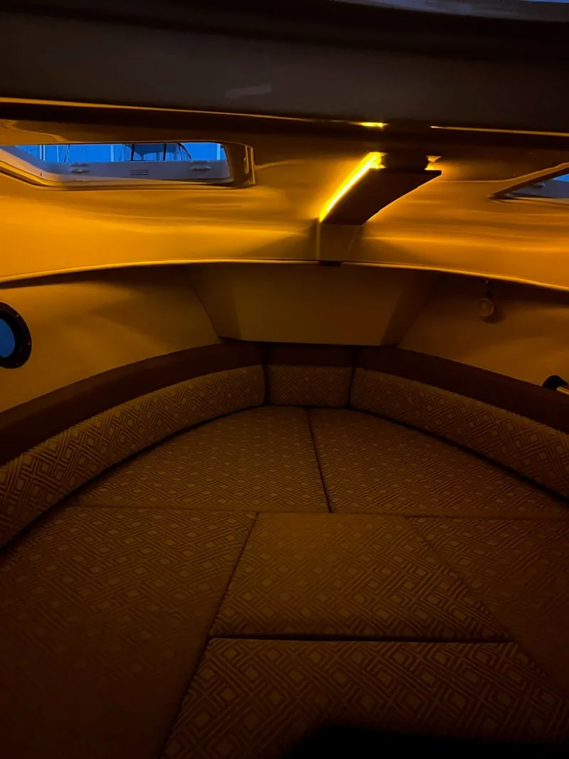 Slide: The Image of 2020 Ranger Tugs R-25 cabin interior with ambient lighting and cushioned seating. - 37