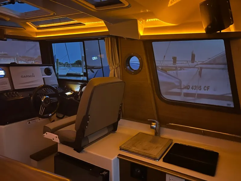 Slide: The Image of Interior of a 2020 Ranger Tugs R-25 boat with illuminated dashboard and seating. - 38