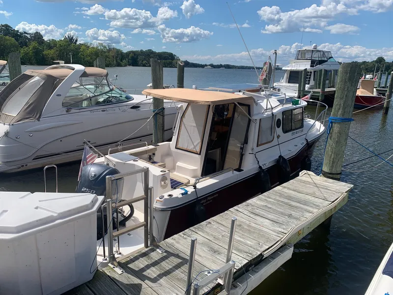 Slide: The Image of 2020 Ranger Tugs R-25 docked at marina under blue sky. - 4