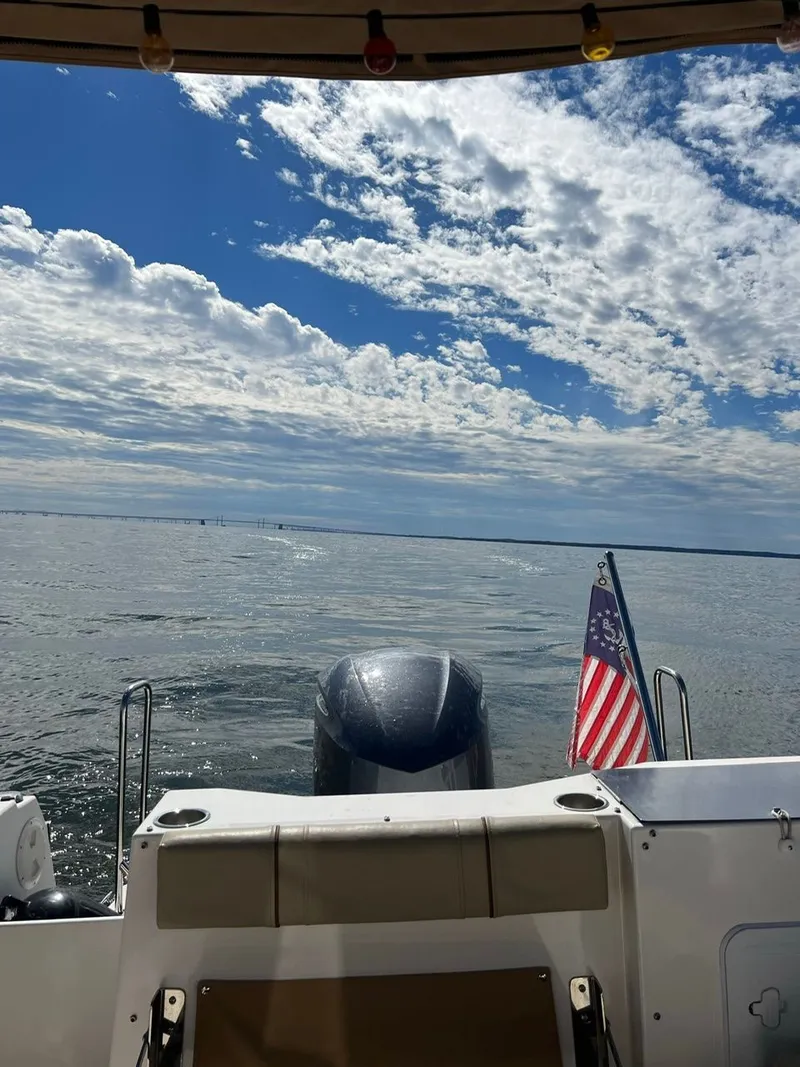 Slide: The Image of 2020 Ranger Tugs R-25 boat on open water, American flag, clear sky. - 41