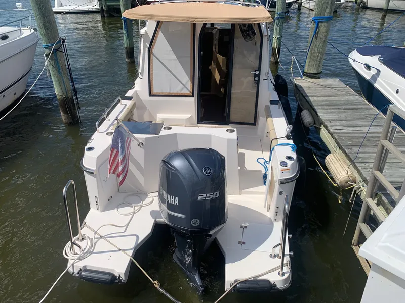 Slide: The Image of 2020 Ranger Tugs R-25 boat docked, featuring Yamaha 250 outboard motor and American flag. - 7