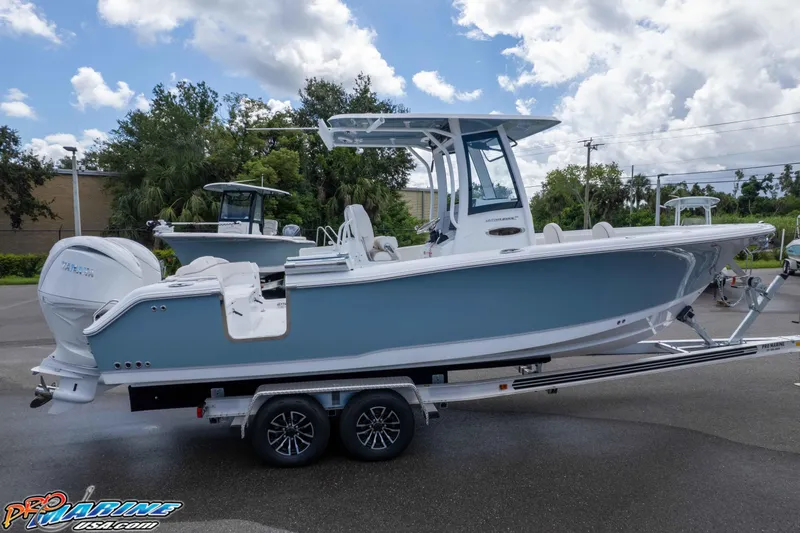 Slide: The Image of 2026 Sea Hunt Ultra 265 SE boat on trailer, parked outdoors under cloudy sky. - 27