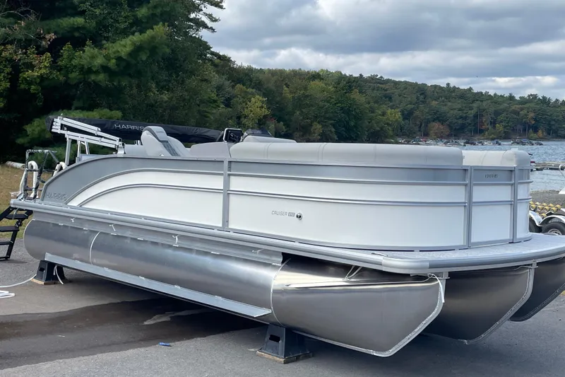 The Image of 2026 Harris FloteBote Cruiser 210 pontoon boat on display by a scenic lakeside. - 1