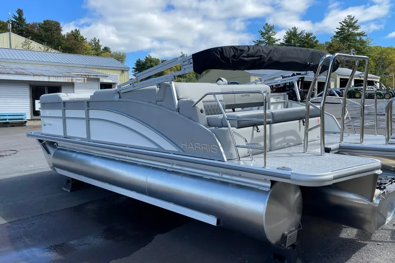 Slide: The Image of 2026 Harris FloteBote Cruiser 210 pontoon boat parked outdoors under a blue sky. - 3
