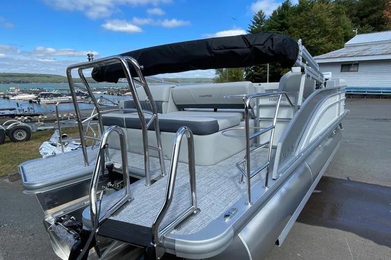 Slide: The Image of 2026 Harris FloteBote Cruiser 210 pontoon boat docked near a scenic lake. - 4