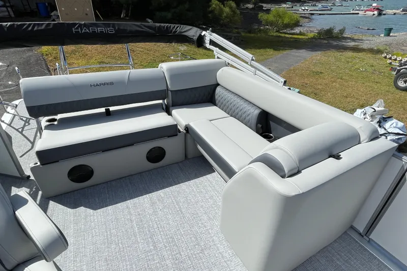 Slide: The Image of 2026 Harris FloteBote Cruiser 210 interior with gray seating, dockside view. - 6