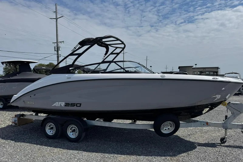 Slide: The Image of 2026 Yamaha Boats AR250 on trailer, sleek design under a partly cloudy sky. - 6