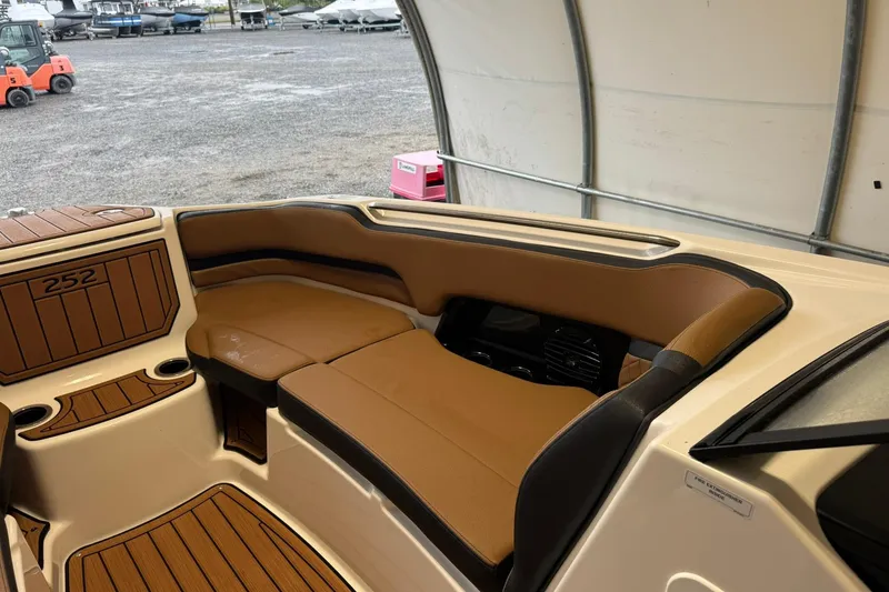 Slide: The Image of 2026 Yamaha Boats 252SD interior with tan seating and wood accents in a covered area. - 13