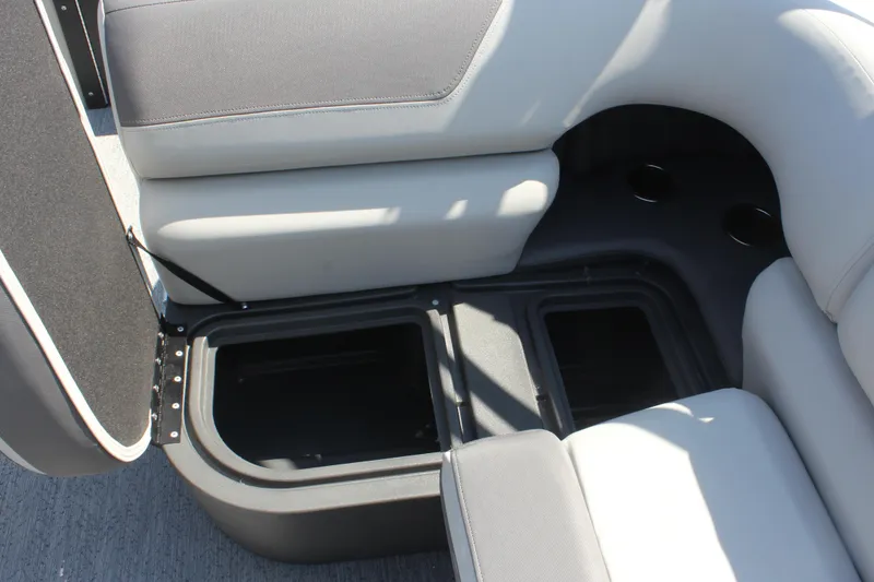 Slide: The Image of 2026 Sun Tracker Fishin' Barge 20 DLX storage compartment with open seat and cup holders. - 15