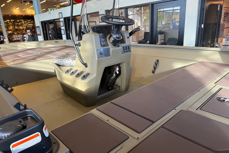 Slide: The Image of 2026 Tracker Grizzly 2072 CC boat interior with steering console and seating. - 2