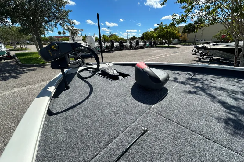 Slide: The Image of 2025 Tracker Savage 215 boat deck with seat and trolling motor under clear blue sky. - 4