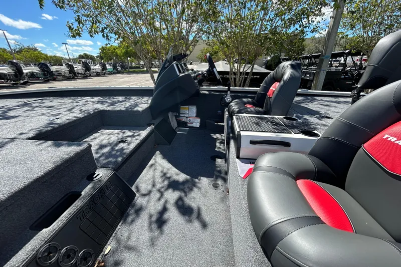 Slide: The Image of 2025 Tracker Savage 215 boat interior with sleek seating and modern dashboard under sunny skies. - 6