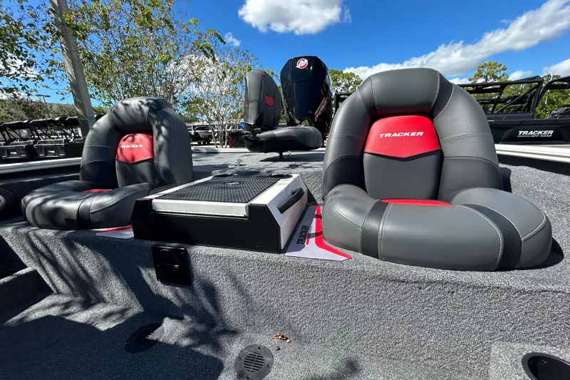 Slide: The Image of 2025 Tracker Savage 215 boat seats with red accents under a clear blue sky. - 7