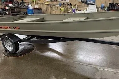 The Image of 2026 Tracker Grizzly 15 Jon boat on trailer in a workshop setting. - 0