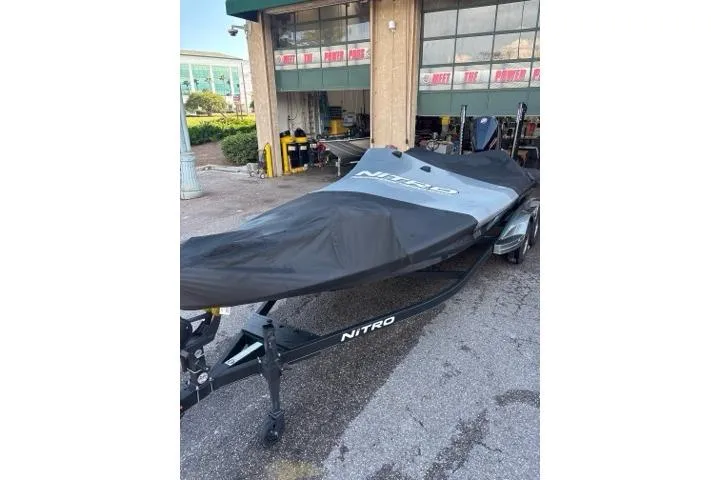 Slide: The Image of 2024 Nitro Z21 XL boat covered, parked outside a garage. - 5