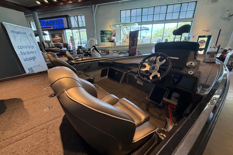 Slide: The Image of 2024 Nitro Z21 XL boat interior with steering wheel and seating in showroom. - 2