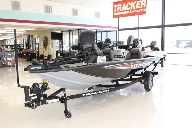 Slide: The Image of 2026 Tracker Pro Team 175 boat displayed in showroom with Minn Kota trolling motor. - 2
