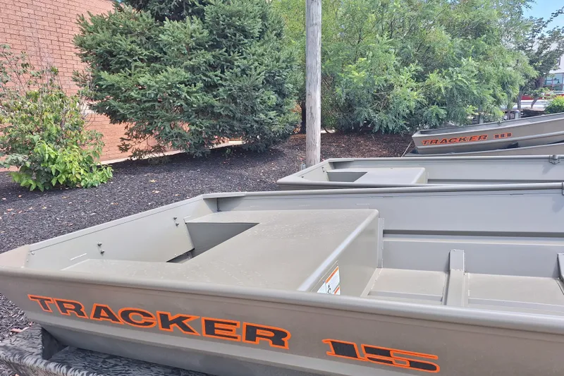 The Image of 2026 Tracker Grizzly 15 Jon boats displayed outdoors near greenery. - 0