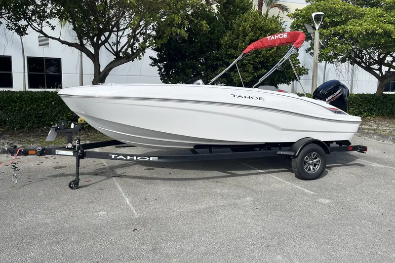 The Image of 2026 Tahoe T18 boat on trailer, white hull, red canopy, parked outdoors. - 0