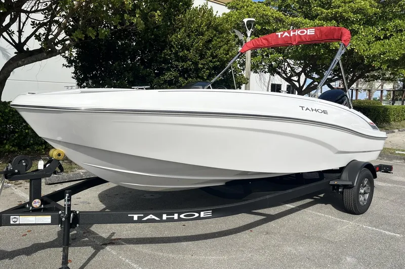 Slide: The Image of 2026 Tahoe T18 boat on trailer with red canopy, parked outdoors. - 2