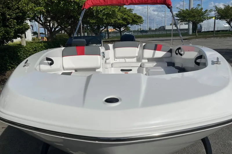 Slide: The Image of 2026 Tahoe T18 boat with red and gray seating, docked outdoors. - 3