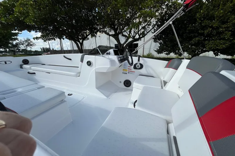 Slide: The Image of 2026 Tahoe T18 boat interior with white and gray seating, steering wheel, and outdoor setting. - 5