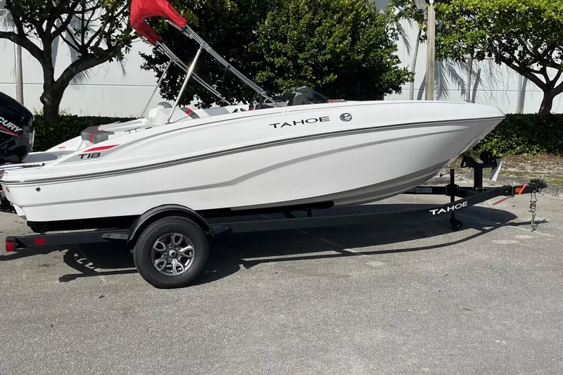 Slide: The Image of 2026 Tahoe T18 boat on trailer, white exterior, parked outdoors. - 9