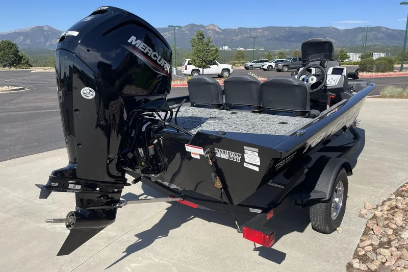 Slide: The Image of 2026 Tracker Pro Team 175 boat with Mercury engine, parked outdoors with scenic mountain backdrop. - 2