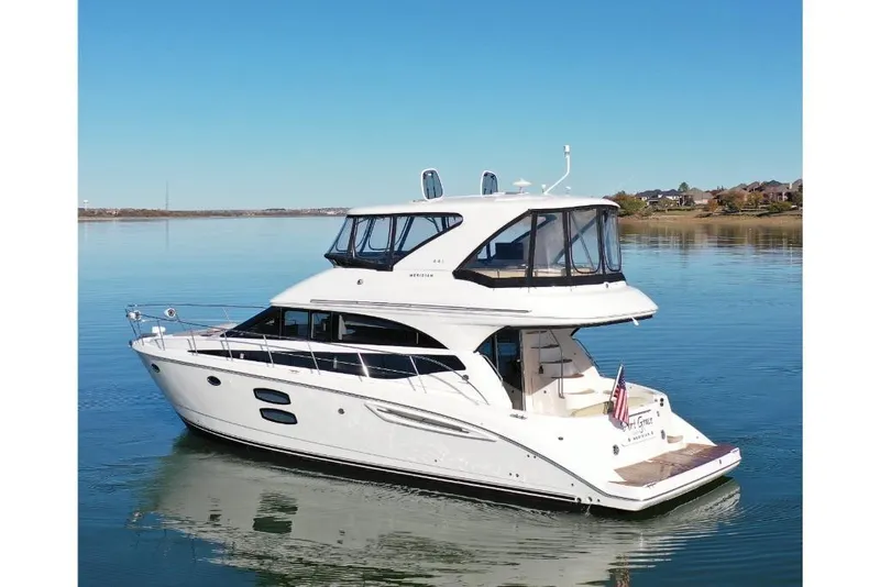 Slide: The Image of 2016 Meridian 441 yacht on calm water, clear sky, and distant shoreline. - 20