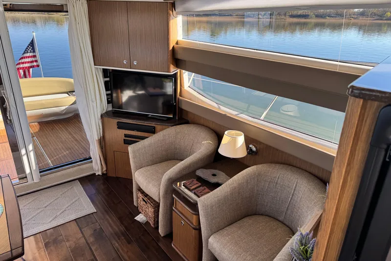 Slide: The Image of Luxurious 2016 Meridian 441 yacht interior with cozy seating, TV, and scenic water view. - 24