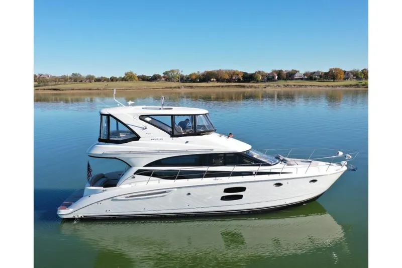 Slide: The Image of 2016 Meridian 441 yacht on calm water, clear sky, scenic background. - 3