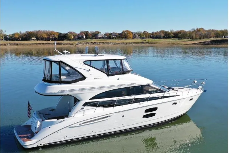 Slide: The Image of 2016 Meridian 441 yacht on calm water, clear sky, scenic background. - 4