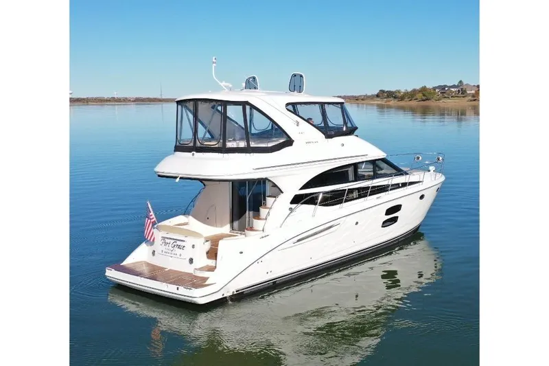 Slide: The Image of 2016 Meridian 441 yacht on calm water, featuring sleek design and spacious upper deck. - 5