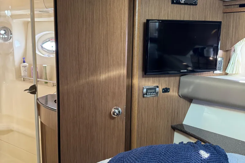 Slide: The Image of 2016 Meridian 441 yacht interior with TV, wooden paneling, and bathroom view. - 52