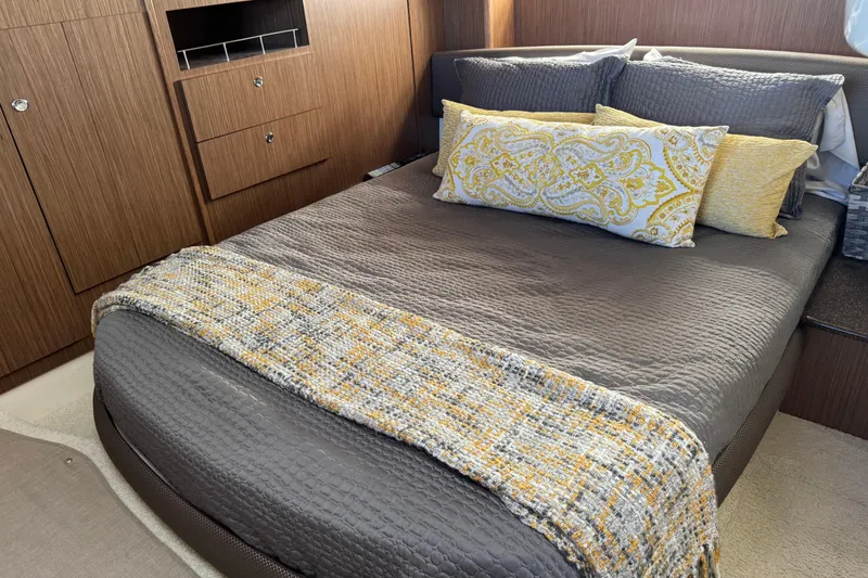 Slide: The Image of Luxurious 2016 Meridian 441 yacht bedroom with elegant bedding and wooden cabinetry. - 57