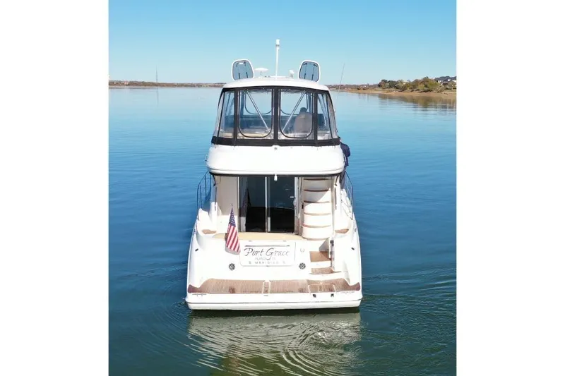 Slide: The Image of 2016 Meridian 441 yacht on calm water, rear view with American flag. - 7